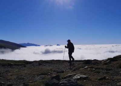 Excursionista caminando desde la cima con niebla cubriendo el valle en Ordesa